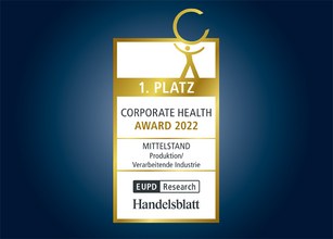 Plakette met gouden en blauwe elementen, vermeldt 1. plaats en Corporate Health Award 2022.  Plakette met gouden en blauwe elementen, vermeldt 1. plaats en Corporate Health Award 2022.